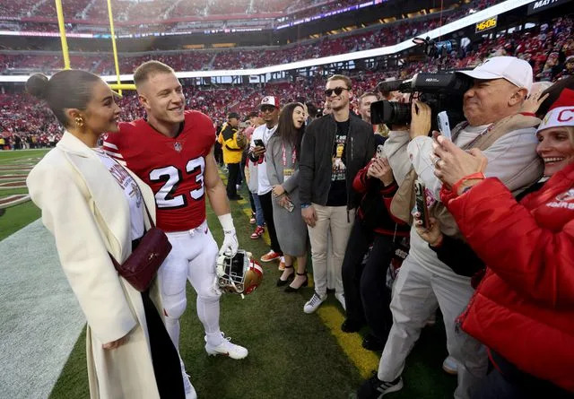 Olivia Culpo and Christian McCaffrey greet fans before the 49ers' game against the Baltimore Ravens in December 2023.