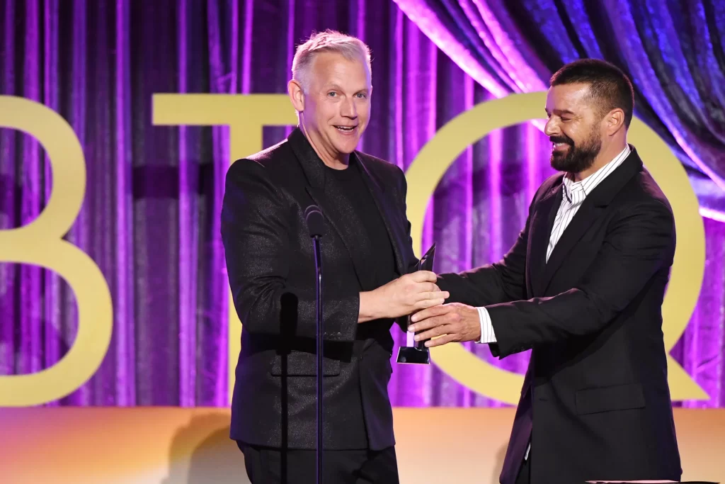 Abe Sylvia accepts a showrunner award from Ricky Martin for his work on Palm Royale